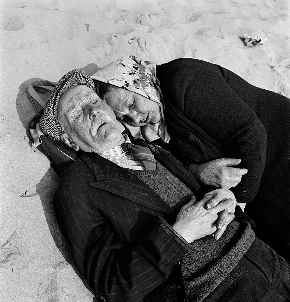 An elderly couple doze on the Blackpool beach, 1955.