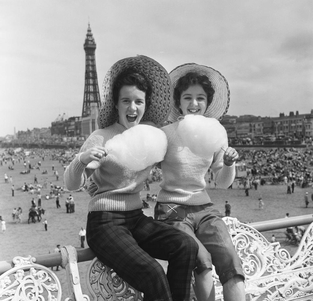 Jean Clark and Mary Cuppler enjoy eating candy floss on the pier at Blackpool, 1957.