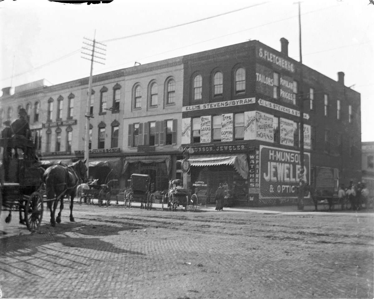 Street view with H. Munson Jeweler and Optics on corner