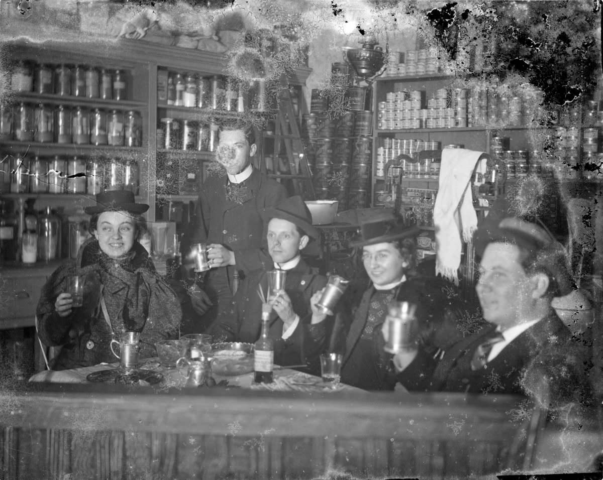 Three men and two women drinking in a shop