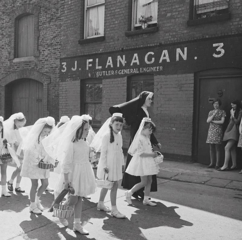 A young nun walking Holy Communion girls past no. 3, Halston Street, Dublin on the feast of Corpus Christi, June 5, 1969