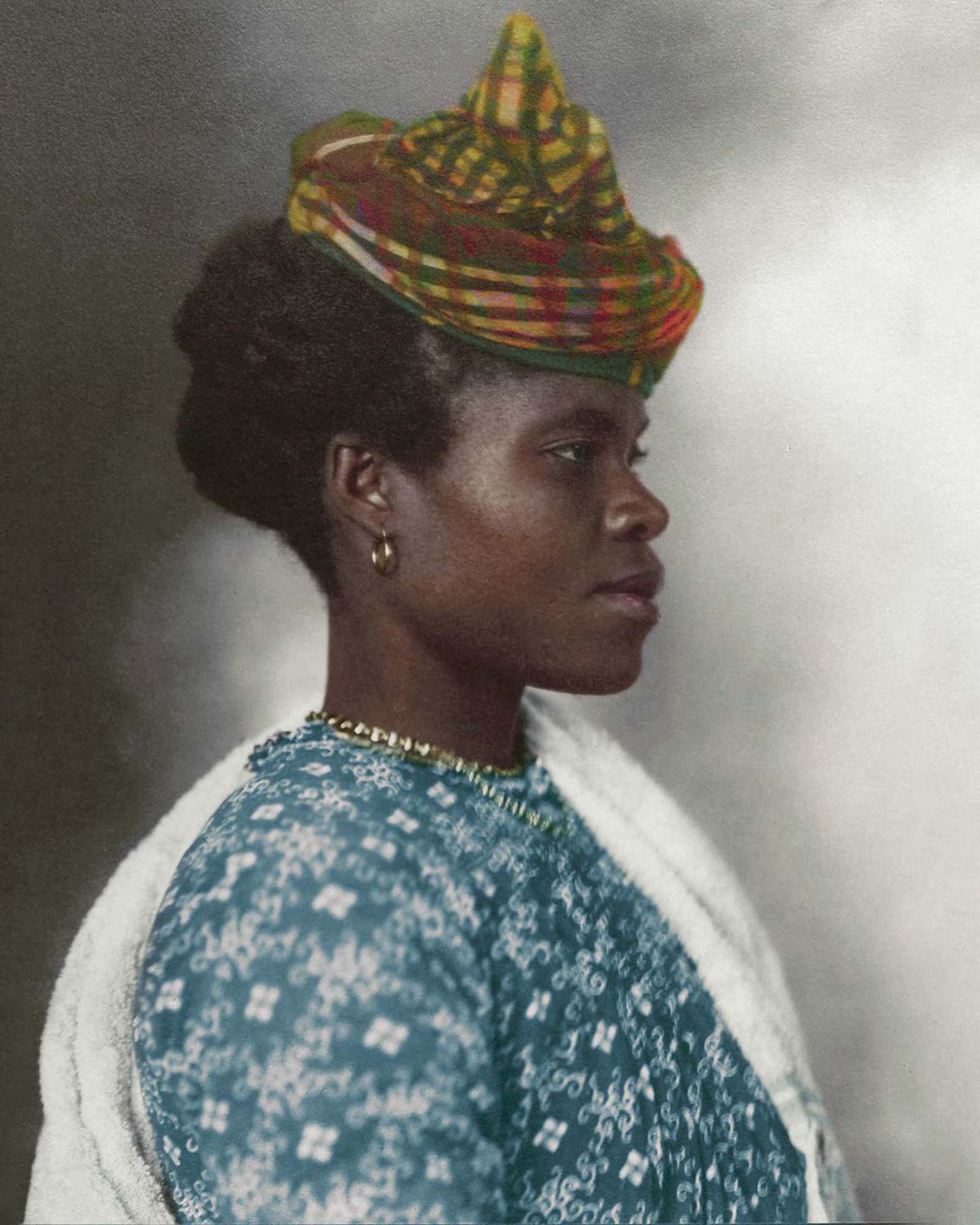 Guadeloupean Woman.” The elaborate tartan headpiece worn by this Guadeloupean woman can be traced back to the Middle Ages, where the eastern Indian city of Madras was famed for its cotton making. First plain, then striped and then with increasingly elaborate patterns, the Madras fabric that was expo