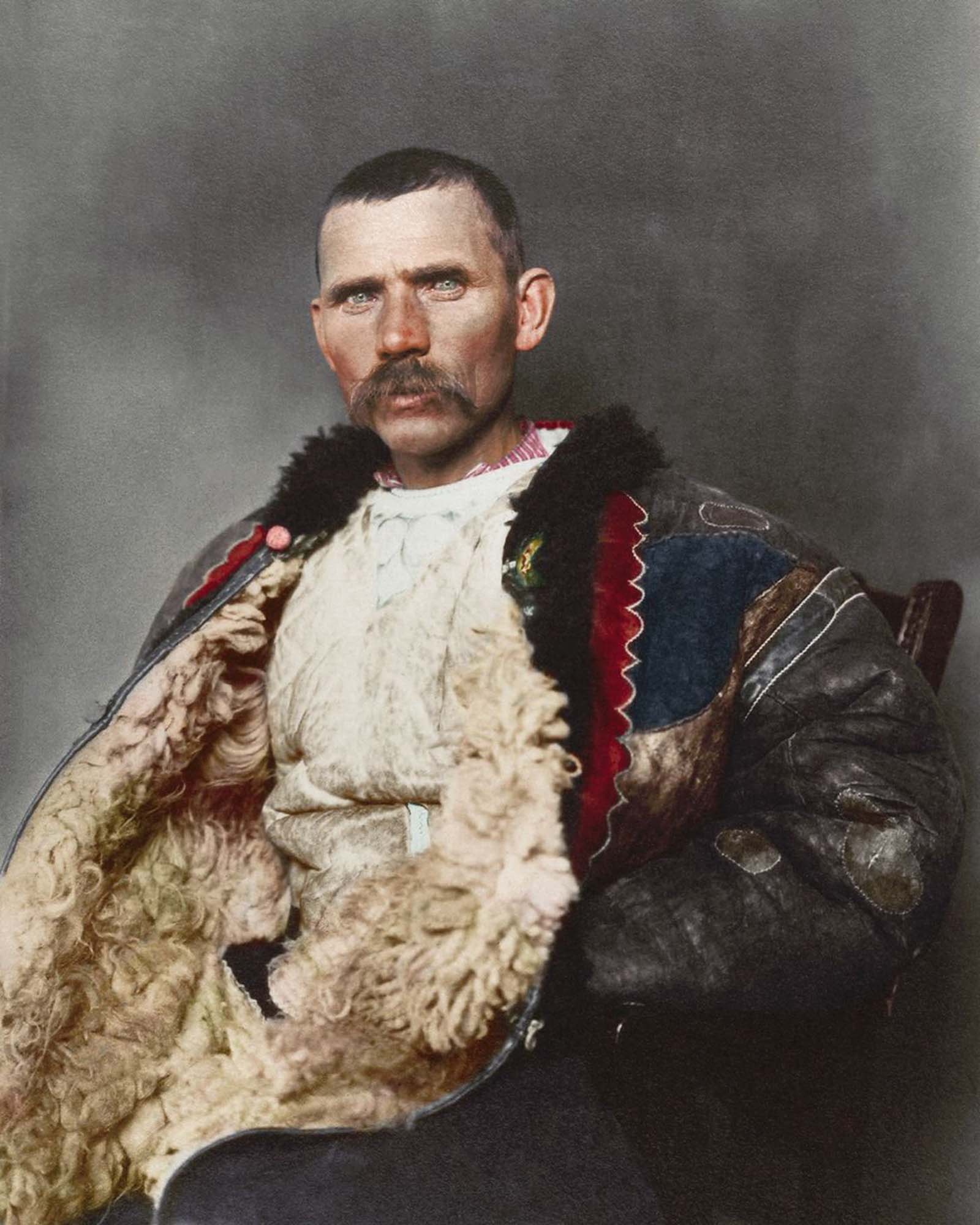 Romanian shepherd.” Dominating the photograph is a traditional shepherd’s cloak known as sarică, made from three or four sheepskins sewn together with the fleece facing outwards and generally extended to below the knee, which could be used as a pillow when sleeping outdoors. Sheepskin was also used