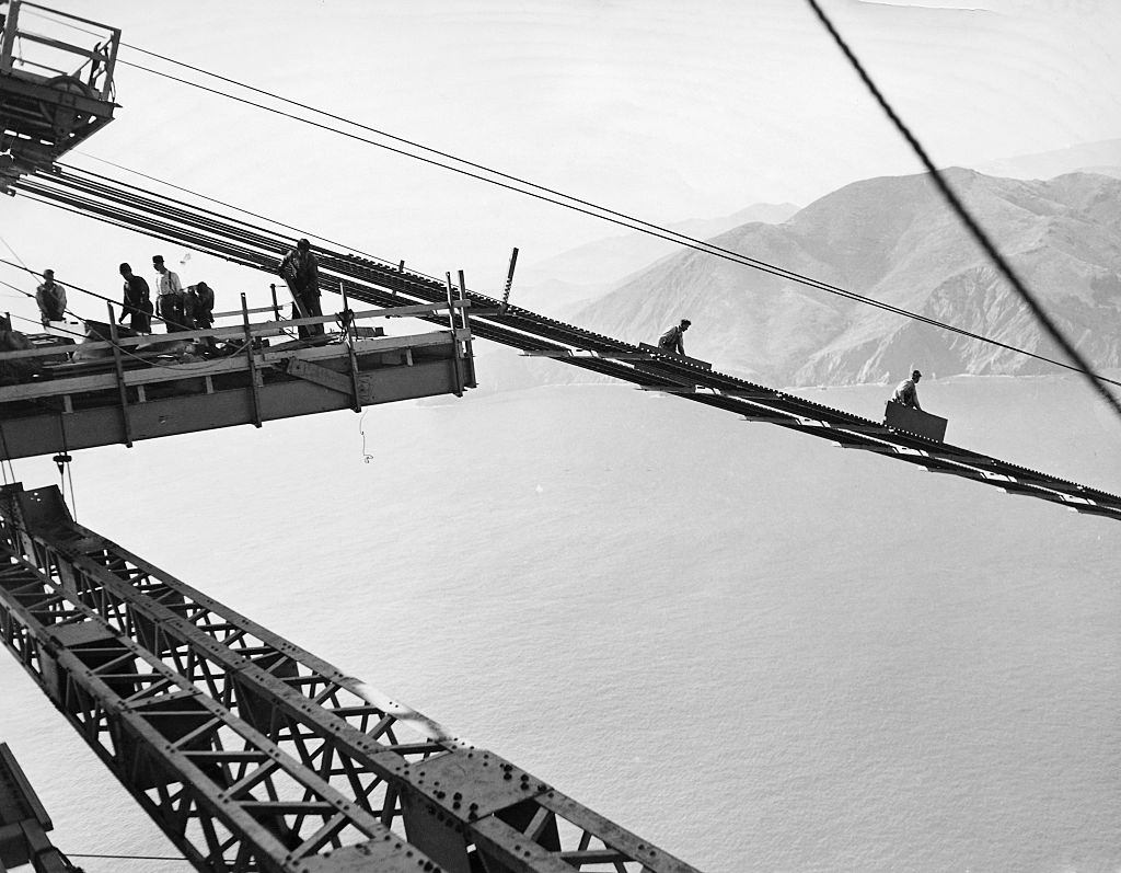 Labors are working on the catwalk, sending pieces down a ramp system, 1930s.