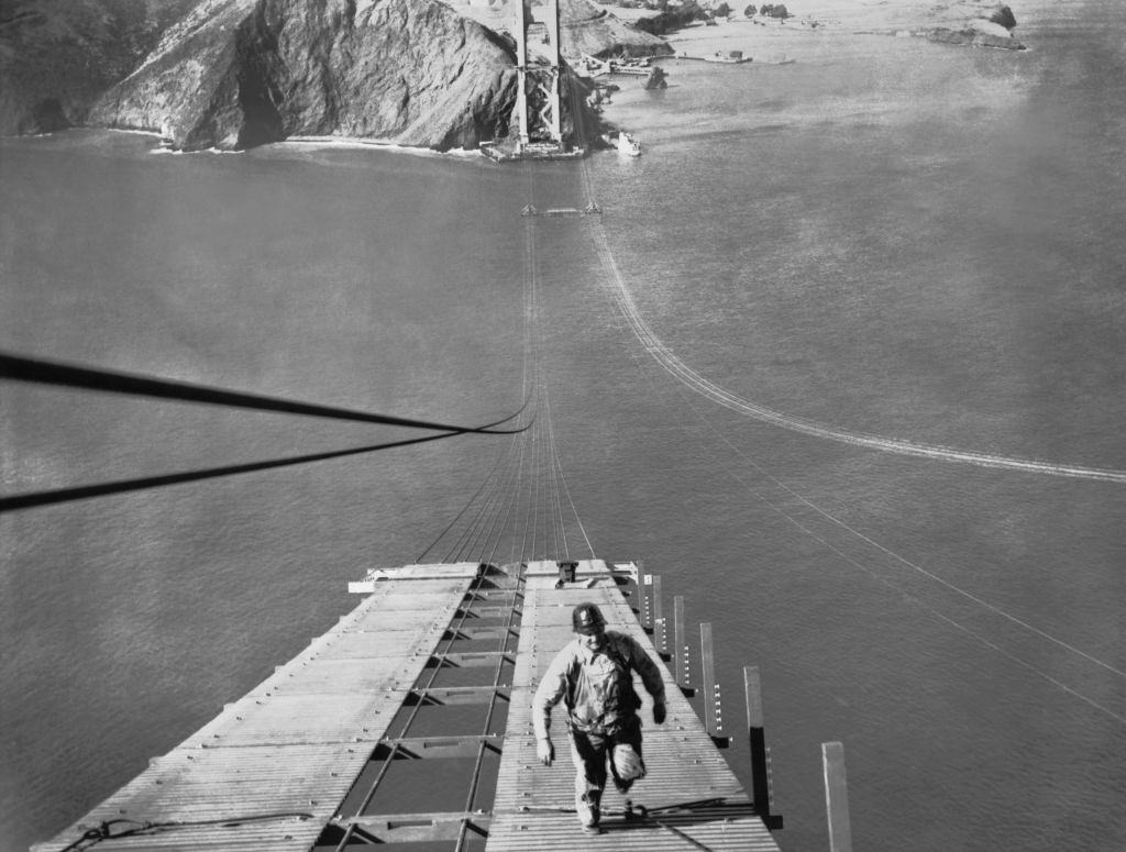 A worker running up one of the catwalks being built for the construction of the cable of the Golden Gate Bridge.