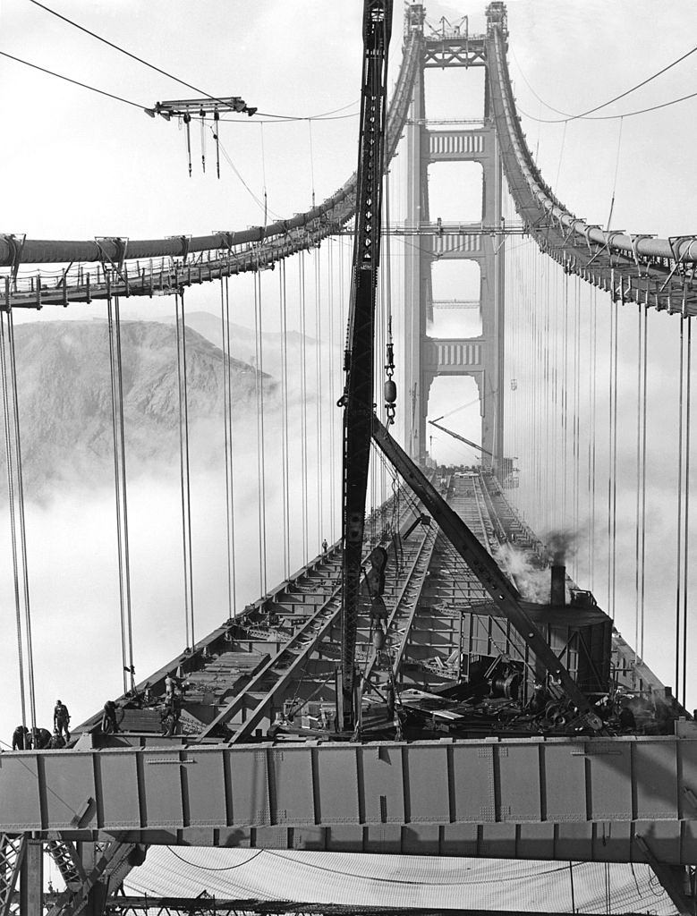 Workers in the fog installing the roadbed during the construction of the Golden Gate Bridge, 1937.