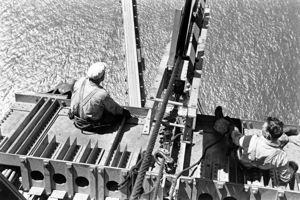 Men sitting on a platform during the construction of the Golden Gate Bridge in San Francisco, 1940.