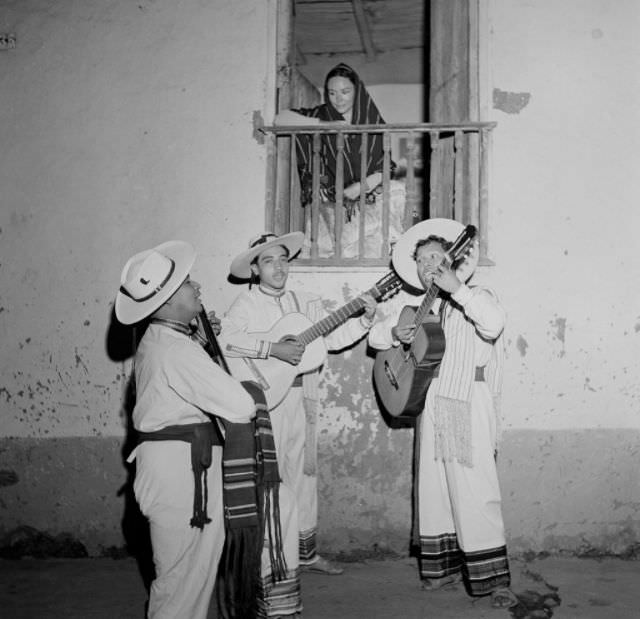 Local boys sing and plays the guitar to serenade a woman in Patzcuaro.