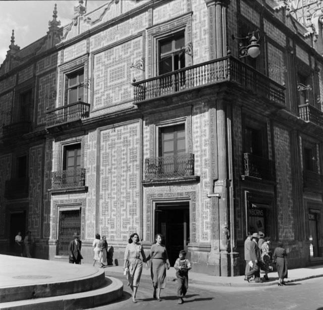 Pedestrians walk through narrow streets and buildings in downtown Mexico City.