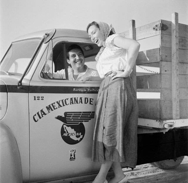 A woman stands on the side board of a CIA Mexicana service truck in Mexico City.