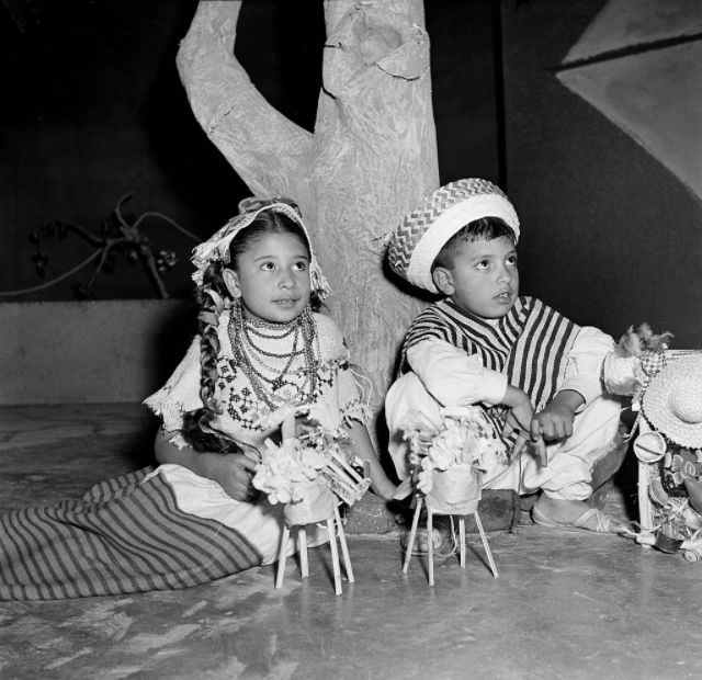 A young boy and girl sell toys at night on a street in Mexico City.