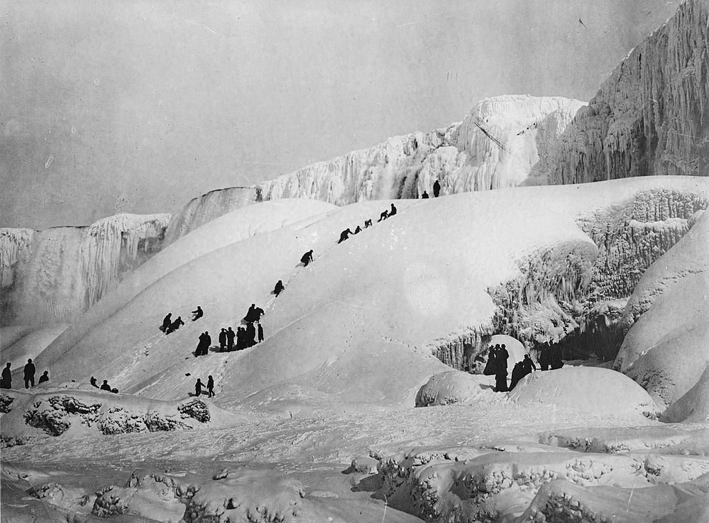 Frozen Niagara Falls with people gamboling over the ice, 1919.