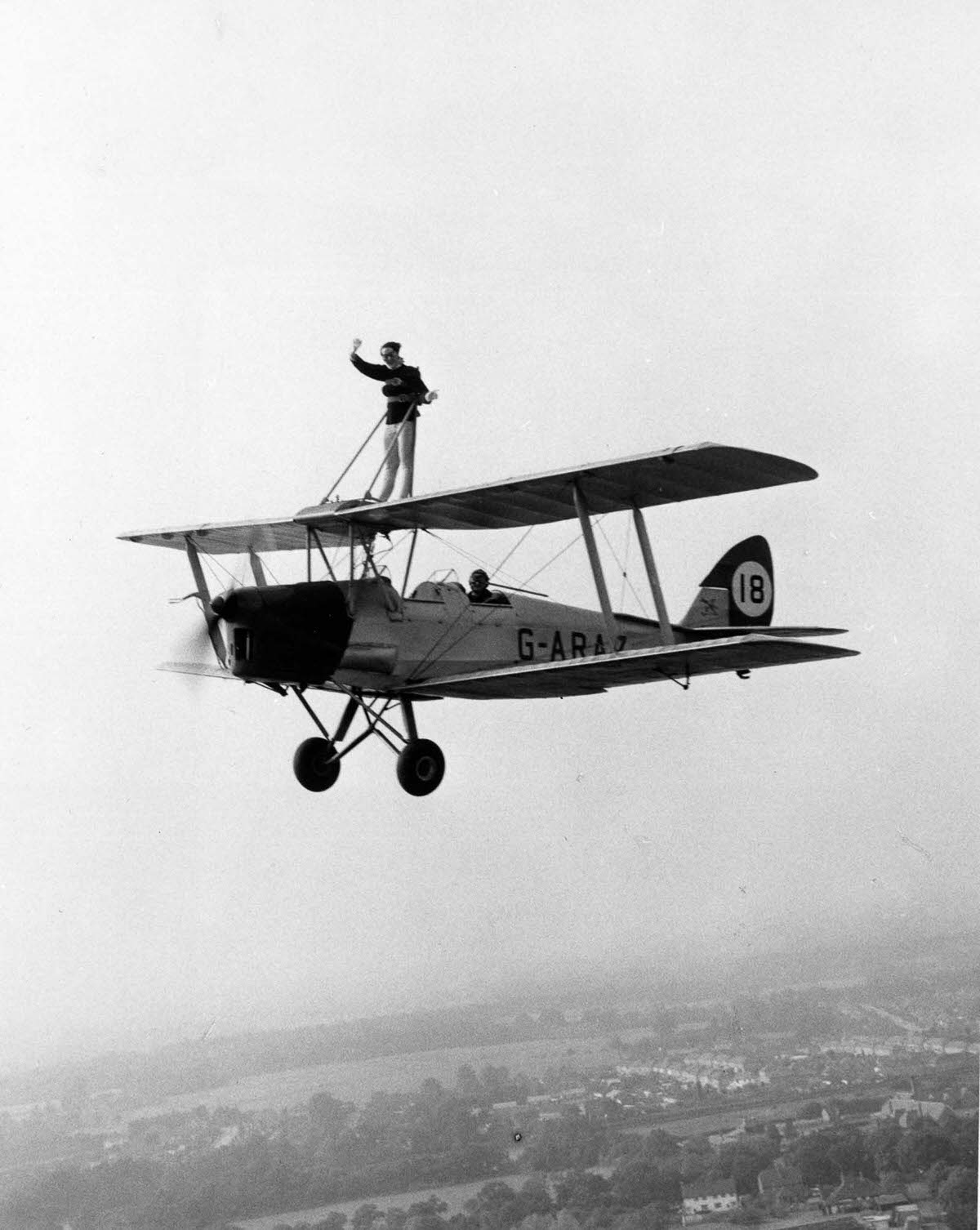 Juanita Jover takes a ride strapped to the wings of her boyfriend, stunt pilot Lewis Benjamin’s Tiger Moth biplane, 1962.