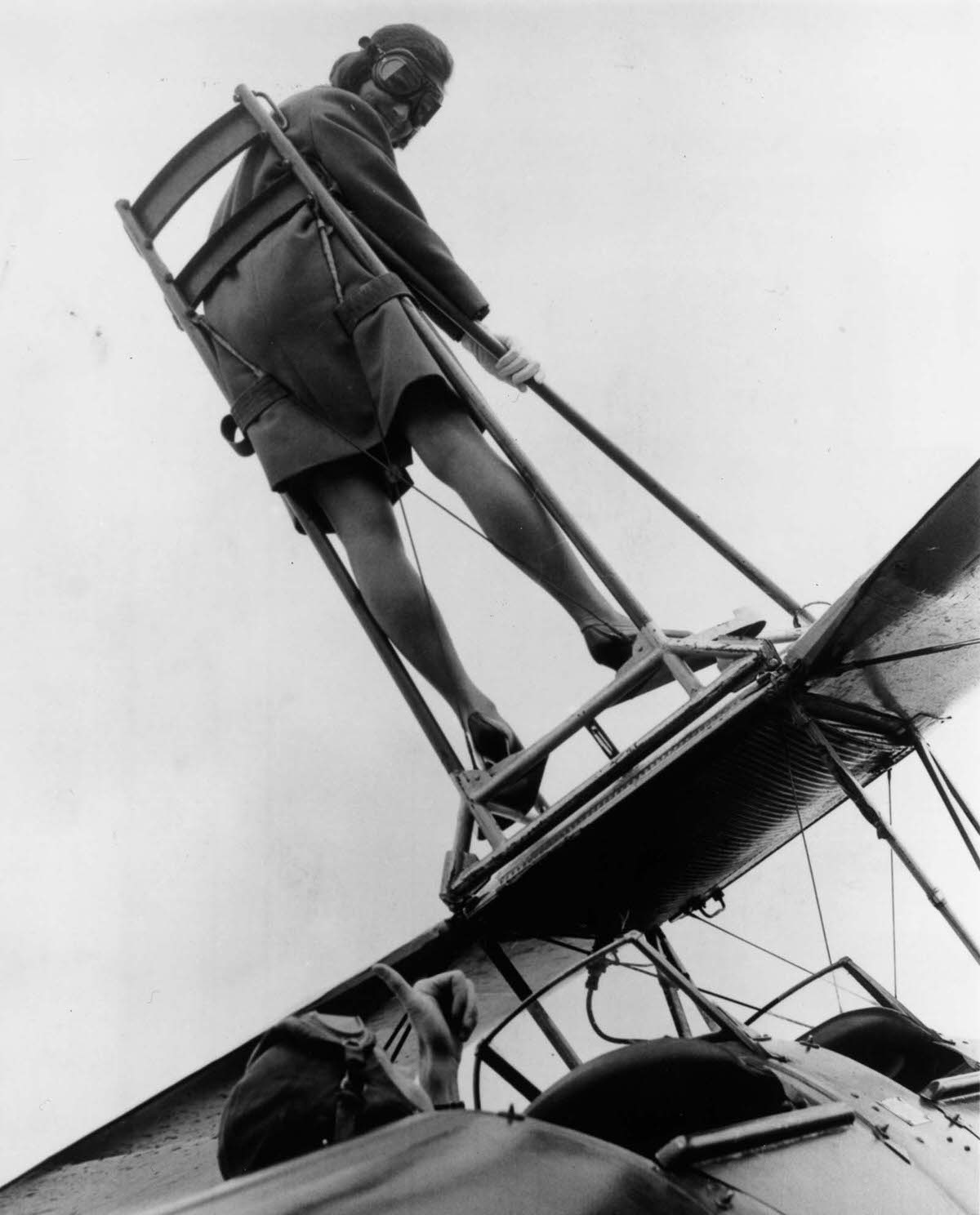 Moira Boyd strapped onto the wing of a Tiger Moth biplane at Wycombe Air Park. 1968.