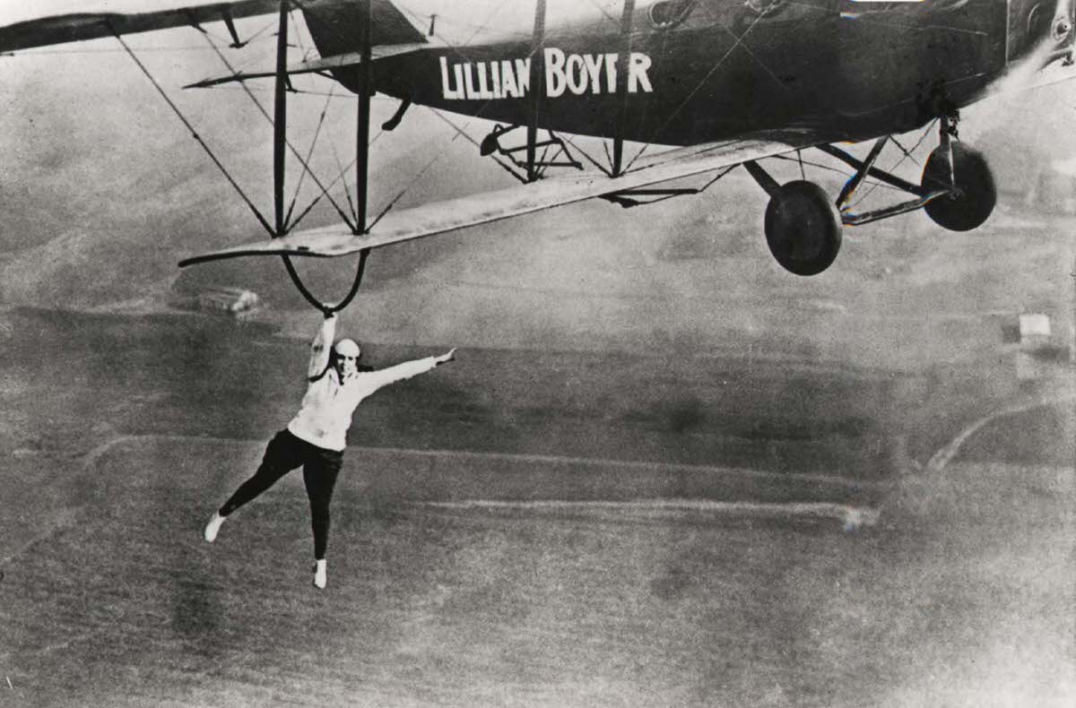 Famous wing walker Lillian Boyer dangles from the wing of a biplane, 1922.