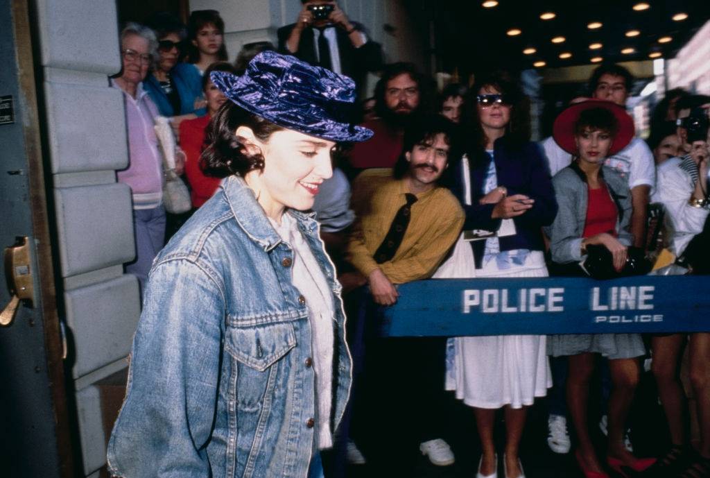 Madonna wearing a purple velvet hat as she leaves a theatre on Broadway, New York City, circa 1988.