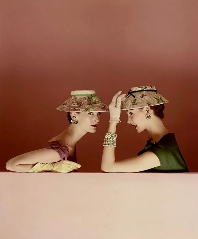 Mary Jane Russell and Cherry Nelms wearing shade-brimmed hats both of painted silk picturing flowers and butterflies, ringed with grosgrain ribbon, 1954