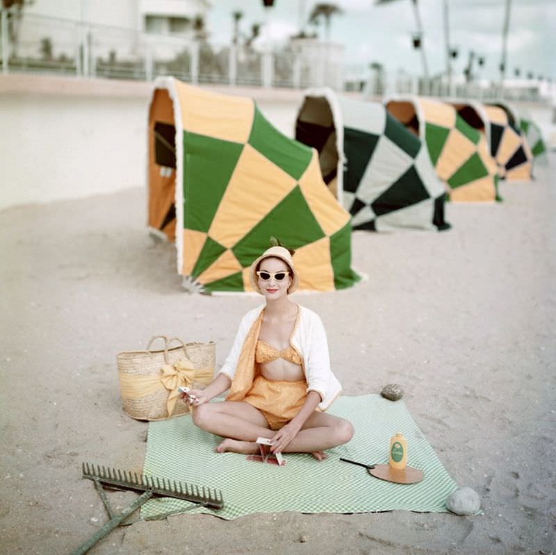 Model is wearing a two piece calico print swimsuit with terry cloth cardy by Cabana, 1959