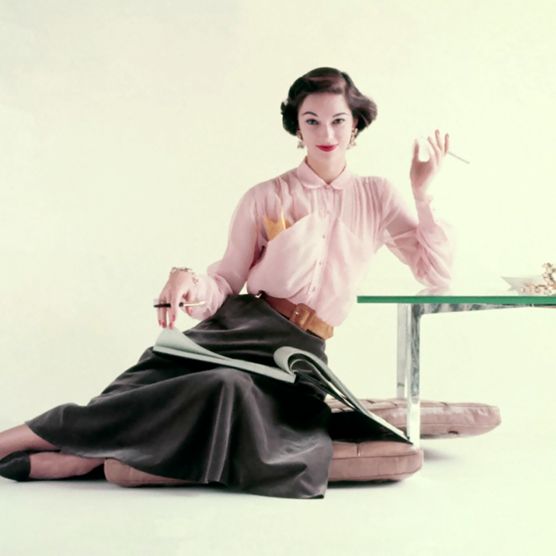 Model is wearing a sheer pink shirtwaist blouse and a bell-shaped skirt by Nelly de Grab, 1952
