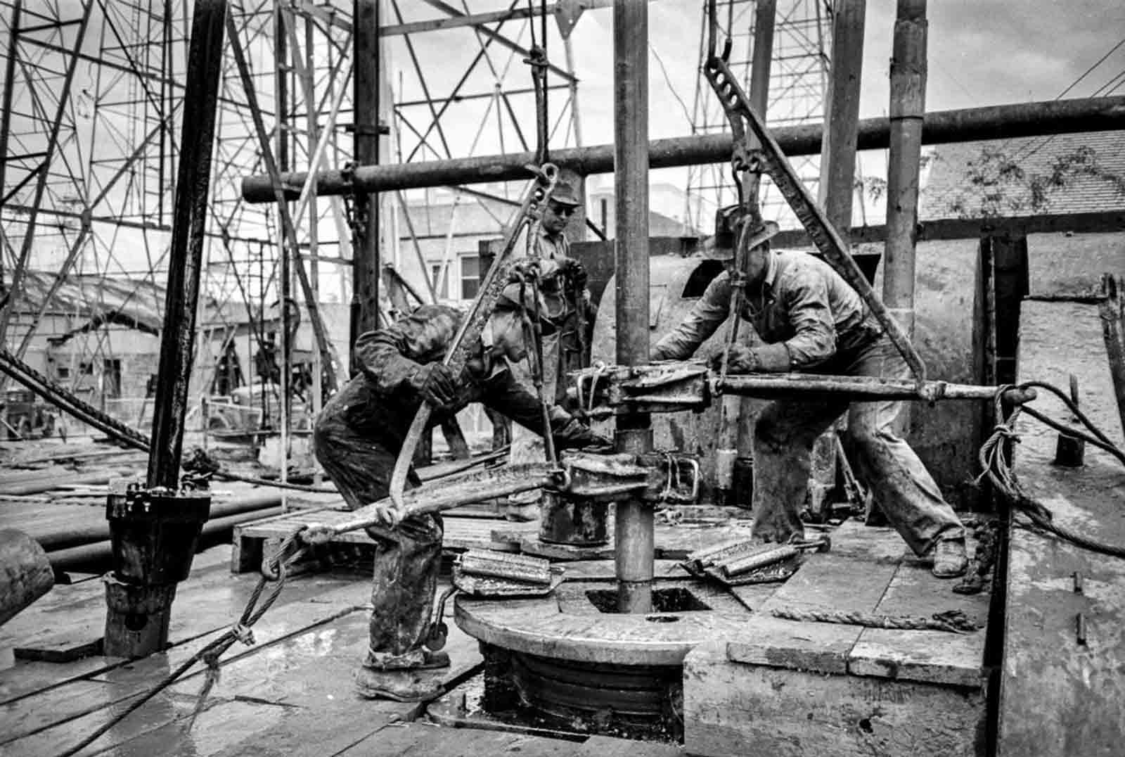 Workers loosen sections of pipe.