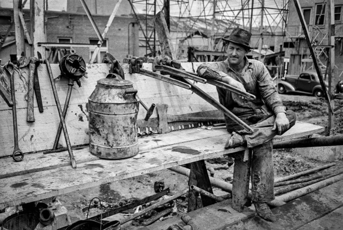 A worker rests next to various tools.