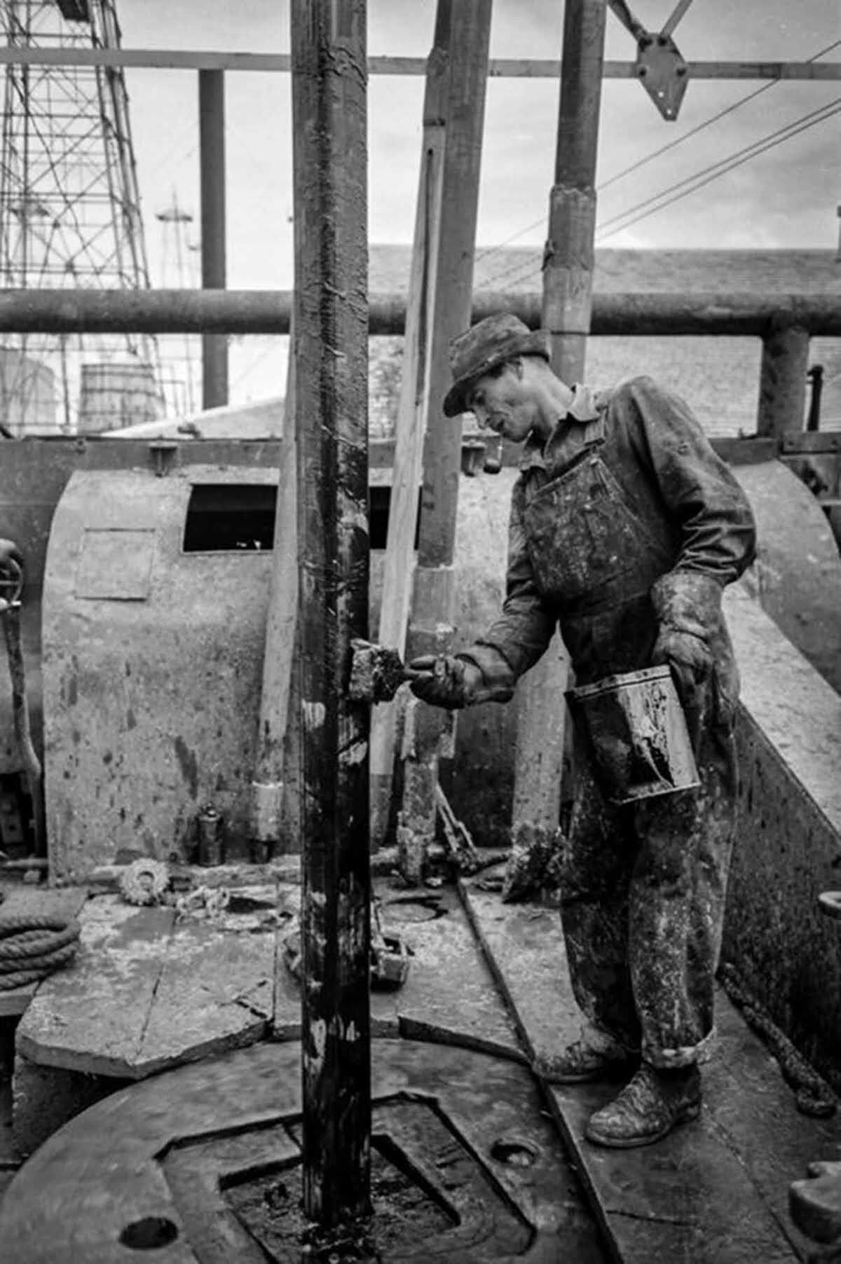 A worker applies grease to the drill stem.