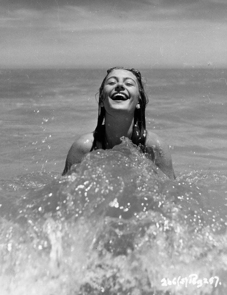 Anouk Aimee taking sun bath on the beach, 1950.