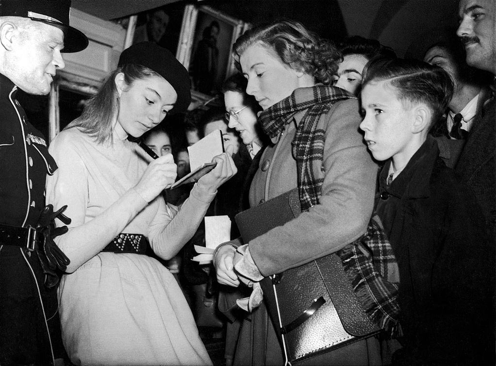 Anouk Aimée signing an autograph, circa 1950.