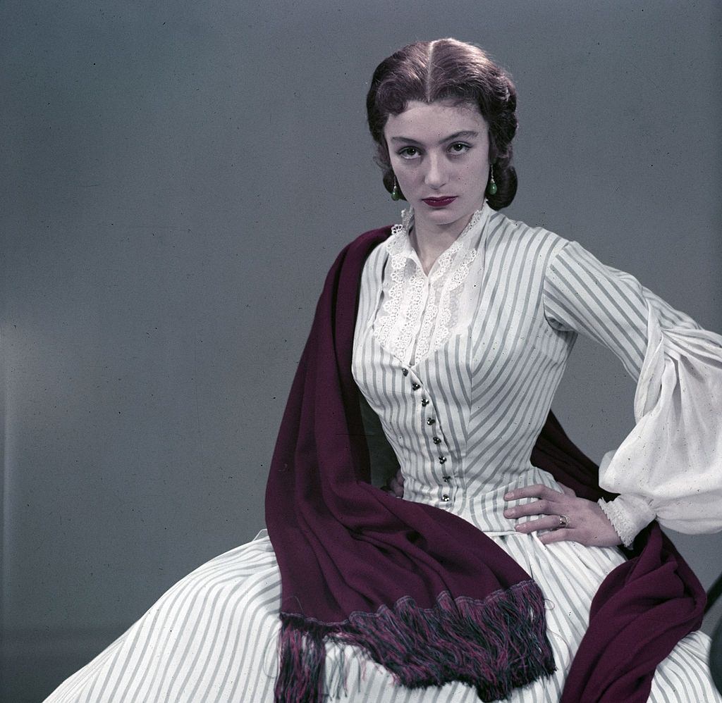 Anouk Aimée in long dress, purple shawl over her shoulder, 1953.