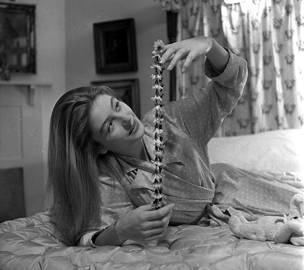 Anouk Aimee with a garland of artificial flowers, 1949.