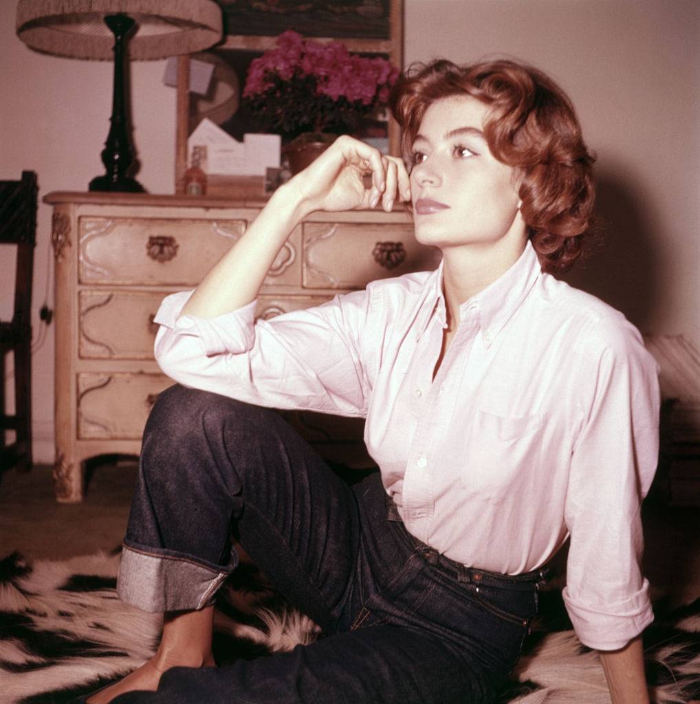 A young Anouk Aimée wearing jeans and shirt in her bedroom , 1955.