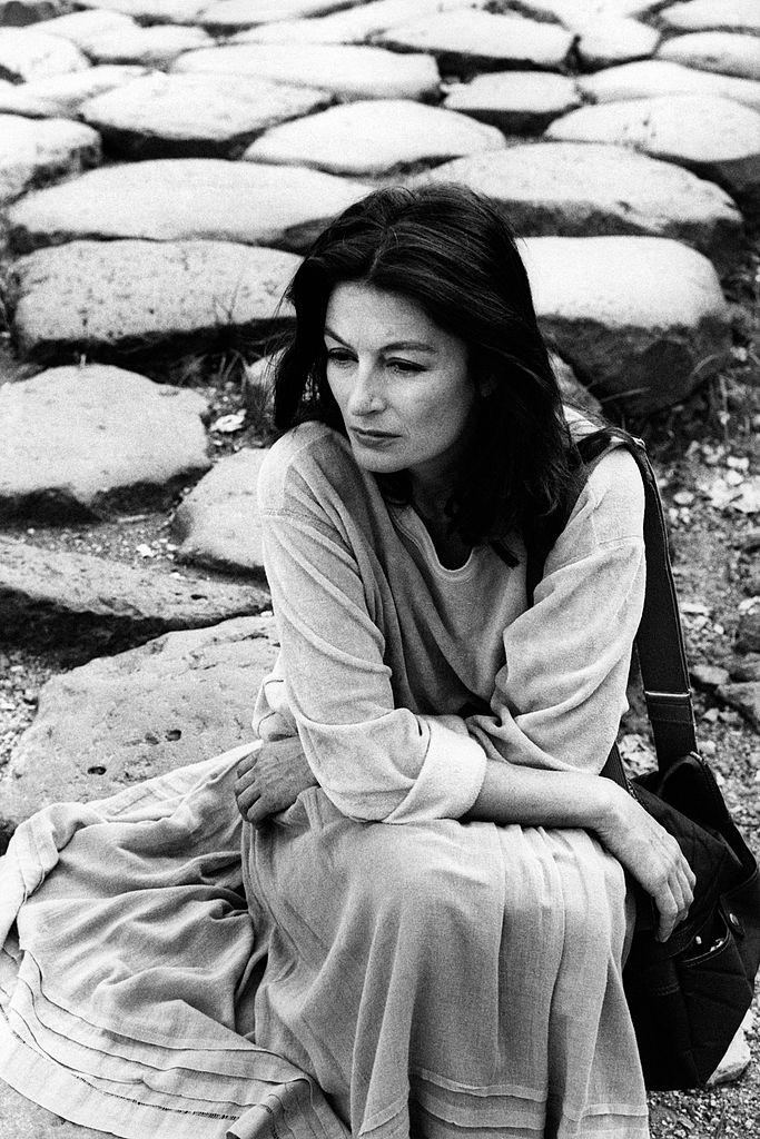 Anouk Aimée sits on the ground, 1975.