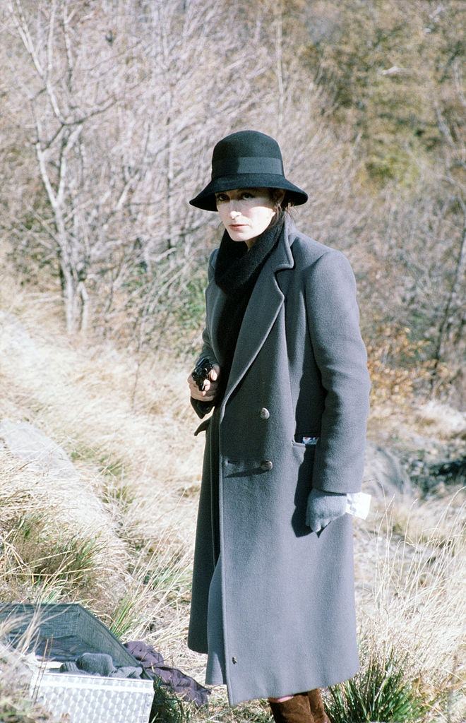 Anouk Aimée holding a gun in a scene of the movie La tragedia di un uomo ridicolo by Bernardo Bertolucci, 1975.