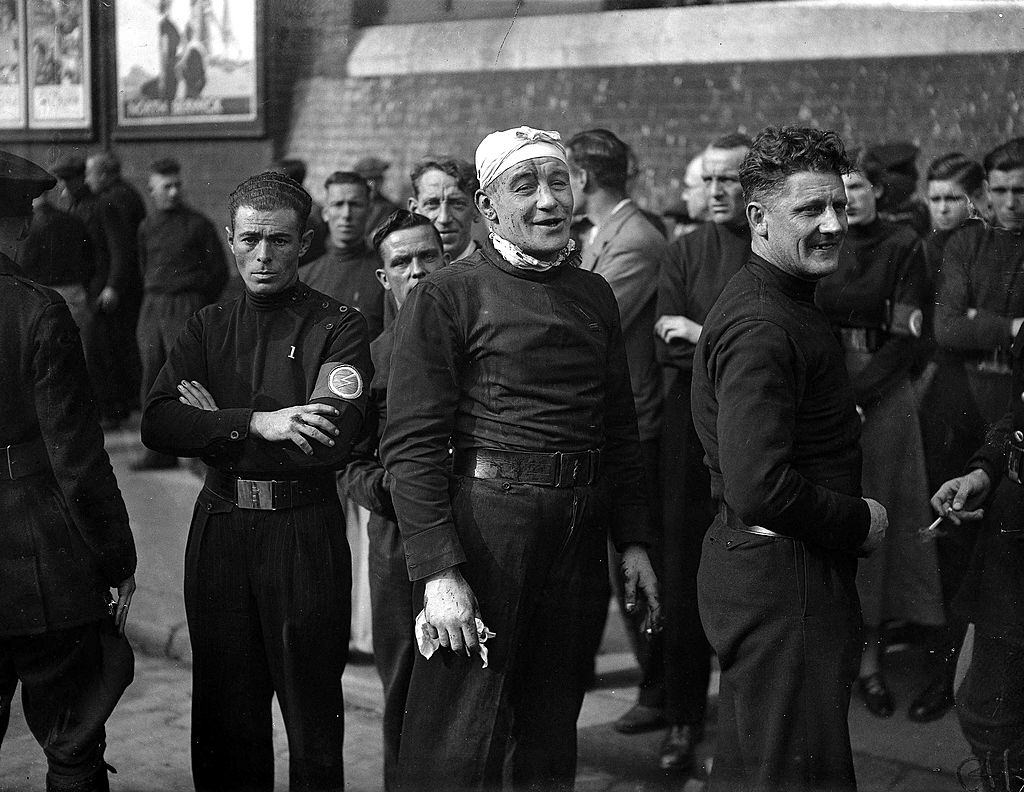 His head bandaged after a blow from a cudgel, an injured British Fascist rejoins the ranks for a mass march through East London, 1936