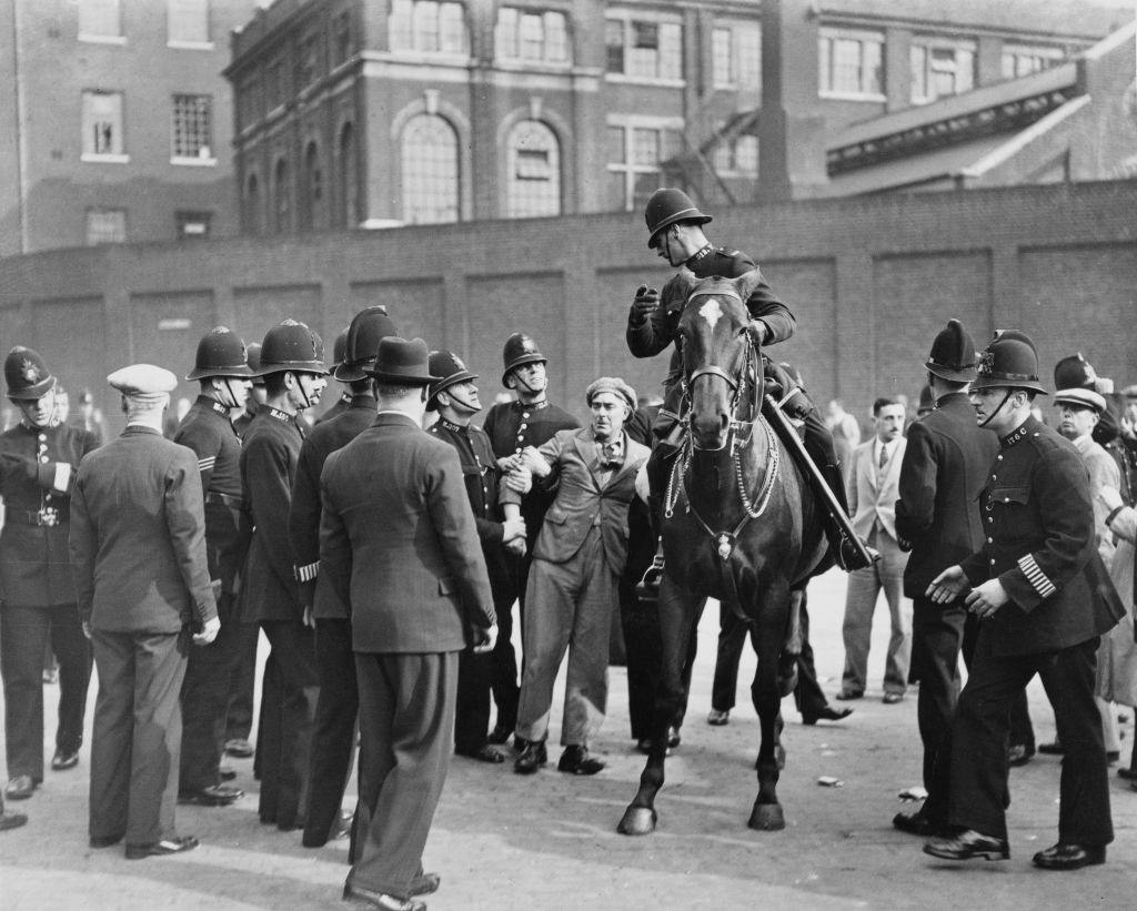 Police arrest a man during a British Union of Fascists demonstration on Royal Mint Street in the East End of London, England, 4th October 1936.