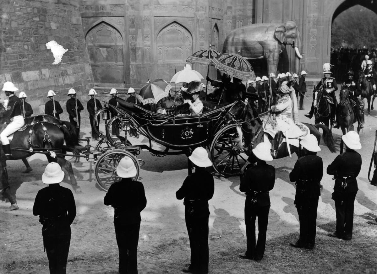 Queen Mary rides past honor guards on the way into Delhi.