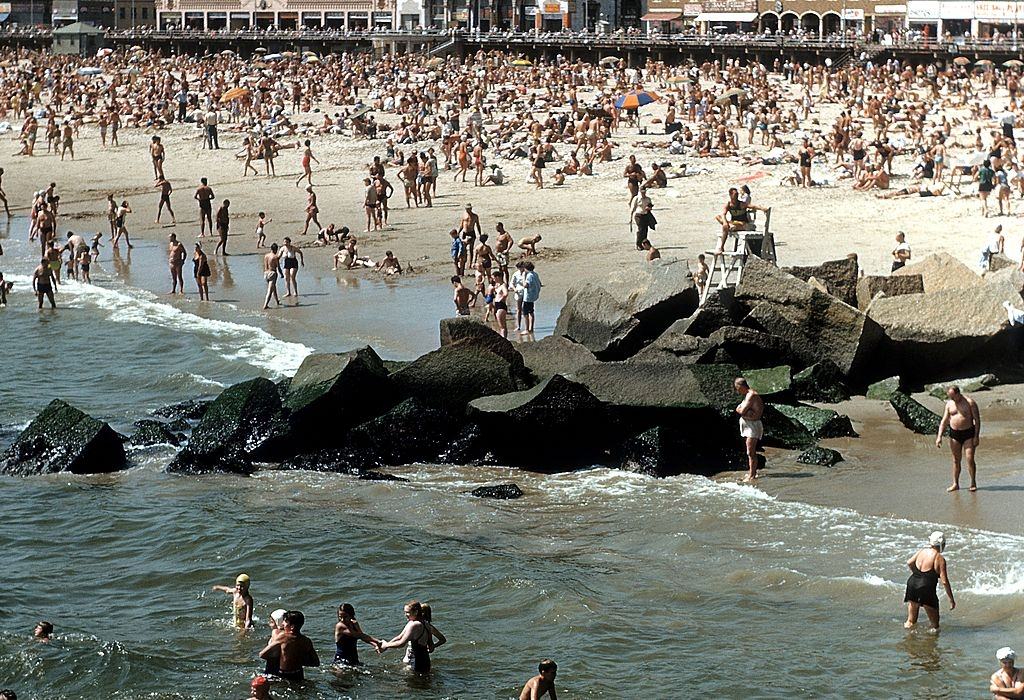Coney Island Boardwalk with sunbathers and swimmers on the beach, 1948.