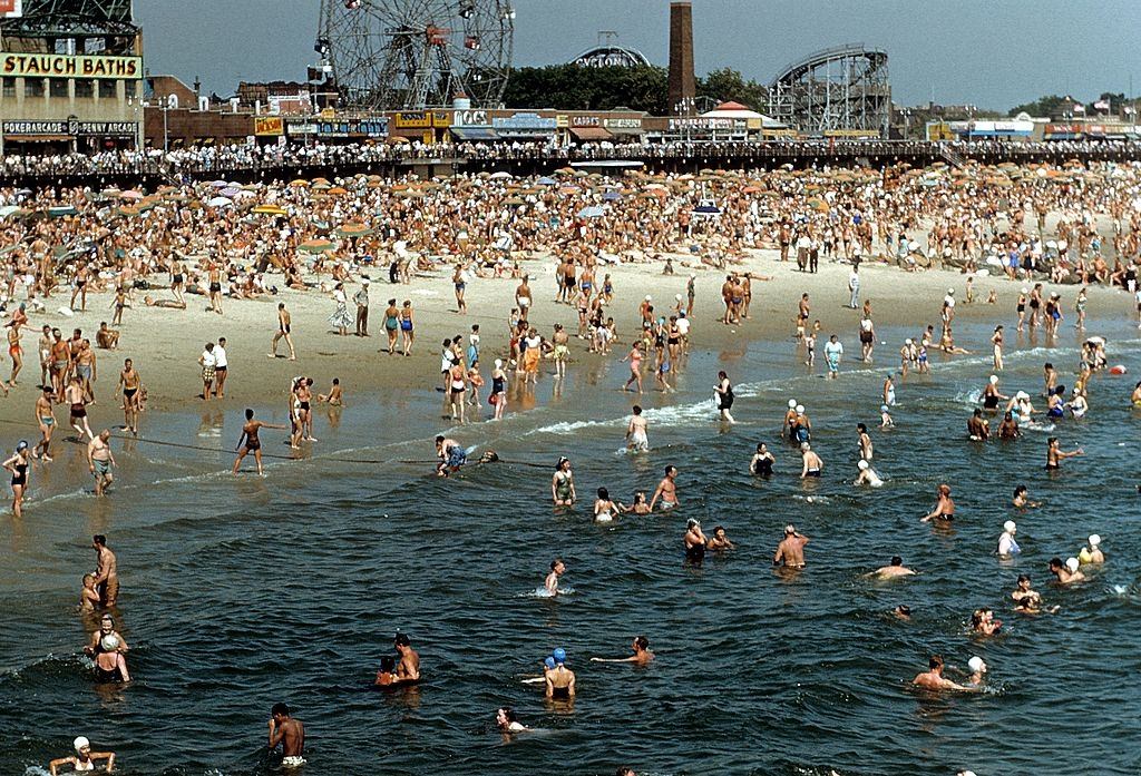 Coney Island Boardwalk with sunbathers and swimmers on the beach, 1948.