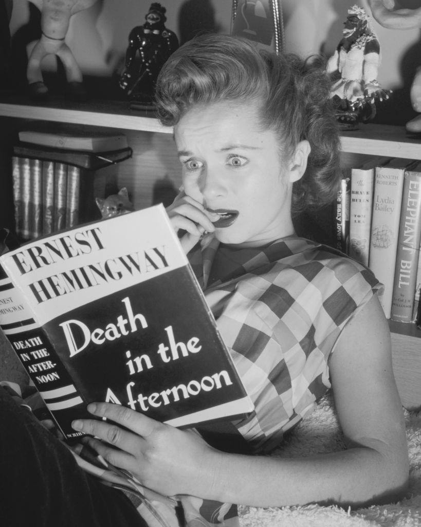 Debbie Reynolds reads Ernest Hemingway's book 'Death in the Afternoon', 1950.