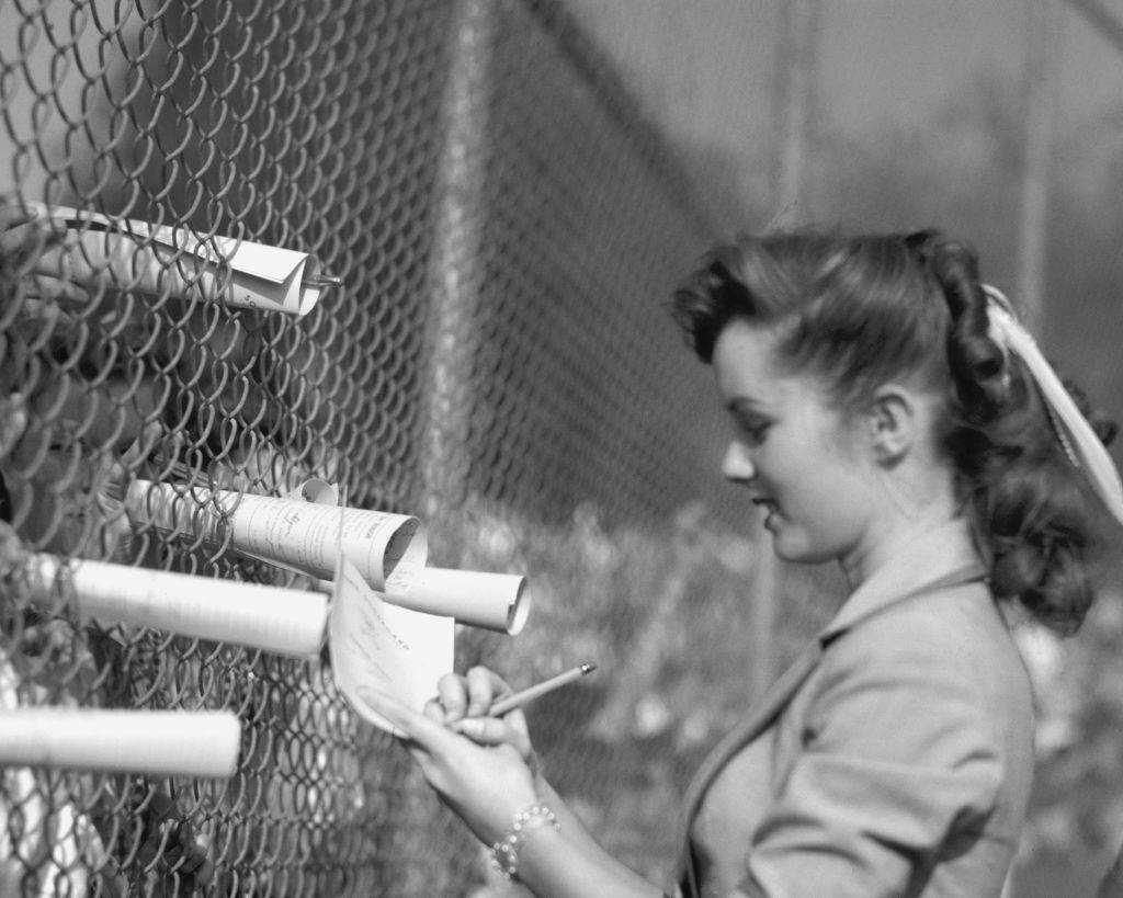 Debbie Reynolds signs scorecards at a sporting event, 1950.