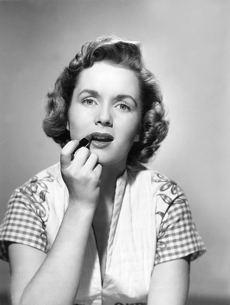 Debbie Reynolds applying lipstick, 1955.