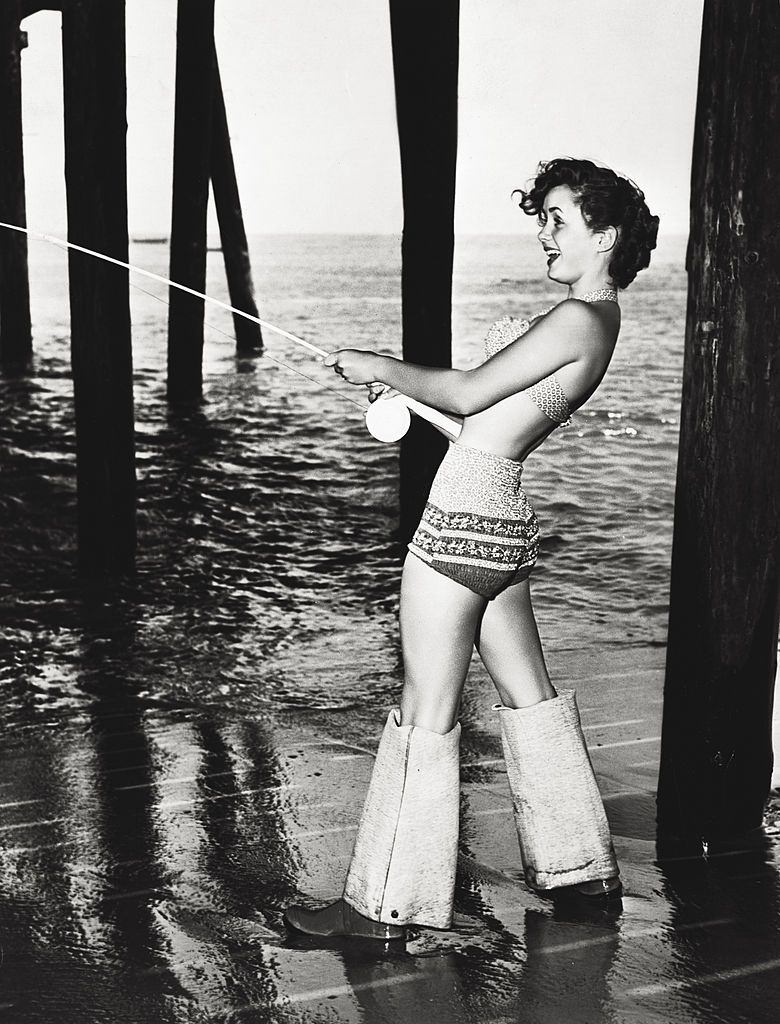 Debbie Reynolds fishing by the sea, during a break in the shooting of 'Three little words', 1950.