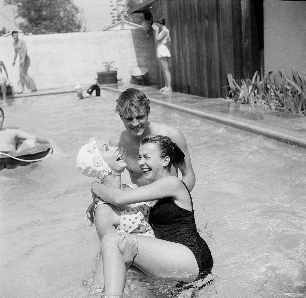 Debbie Reynolds entertains guest at her pool party, 1955.