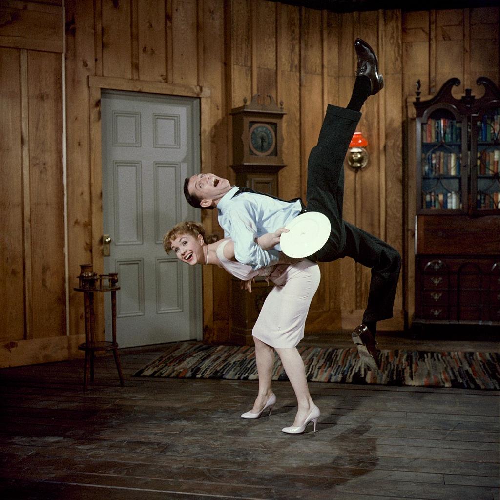 Debbie Reynolds lifts fellow actor Tony Randell, 1959.