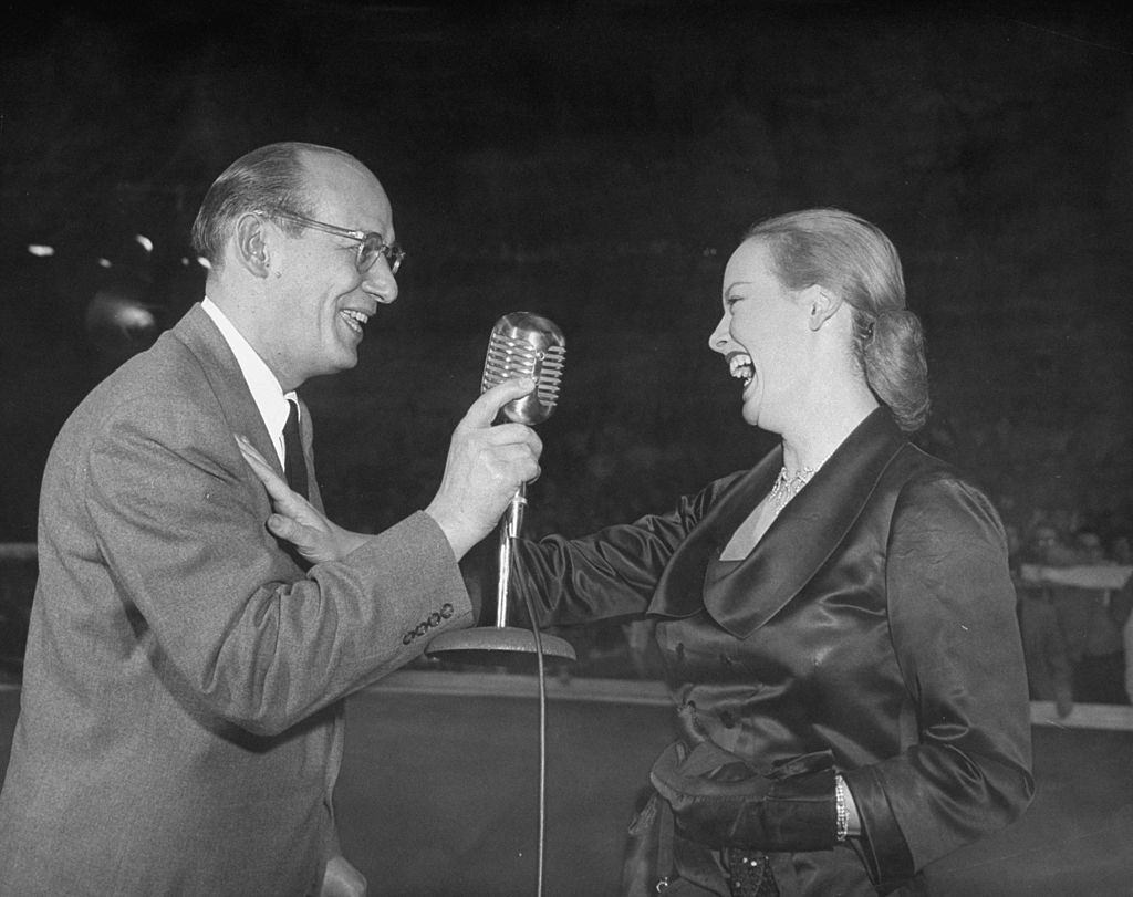 Faye Emerson with Ted Husing talking it up during a Roller Skating Derby, 1950.