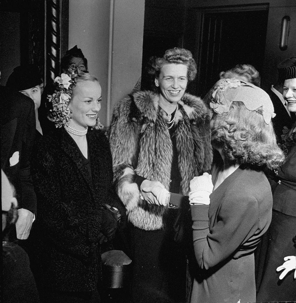 Faye Emerson chatting with woman at cocktail party given by Robert E. Hannegan, 1945.