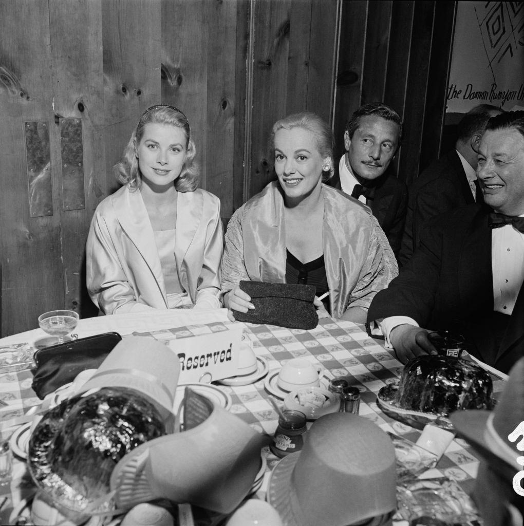 Faye Emerson with Grace Kelly, Oleg Cassini and restauranteur Bernard 'Toots' Shor at a party for the Damon Runyon Theater, 1955.