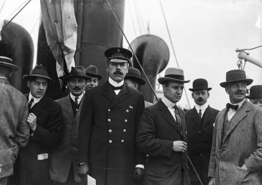 Customs Inspector Malcolm Reid stands aboard the Komagata Maru with MP Henry Herbert Stevens and journalists.