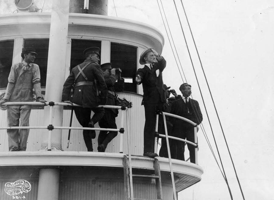 A man sends semaphore signals from the Sea Lion tug.