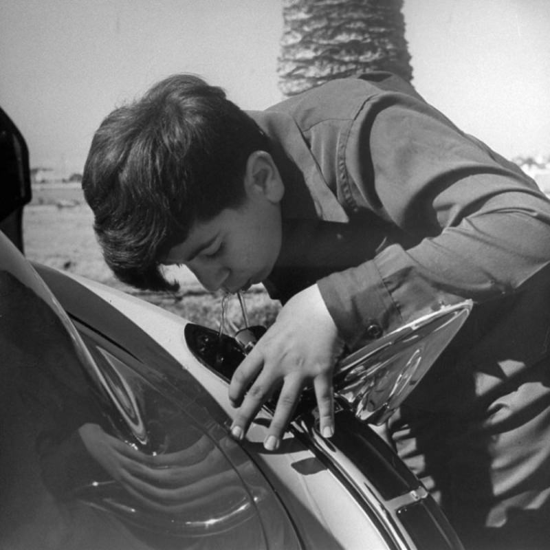 A boy drinks from a water fountain that Louis Mattar installed in his 1947 Cadillac.